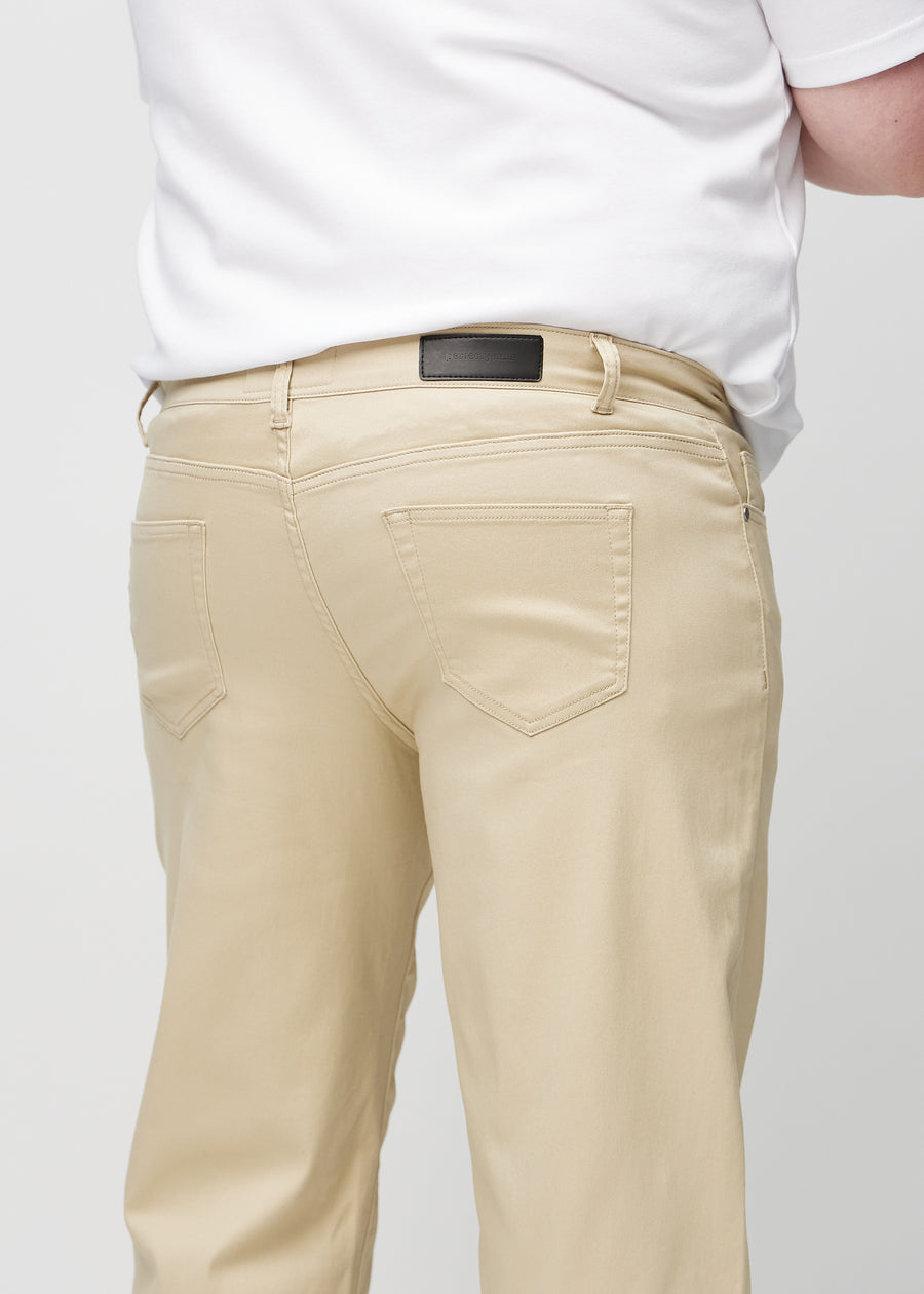 Beige regular jeans sett bakfra på nært hold på en plus-size-modell for å vise detaljer.