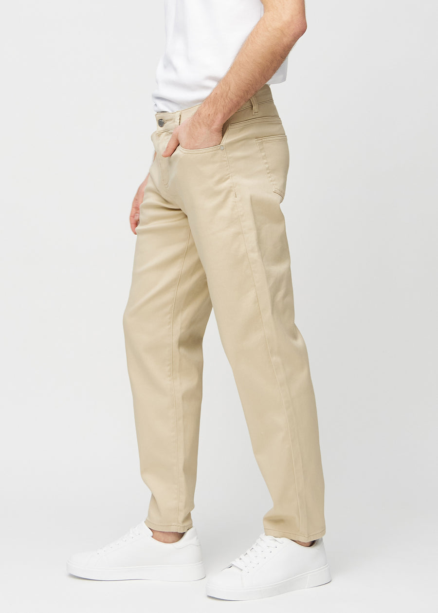 Beige regular jeans sett fra siden på modell.