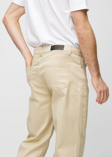 Beige regular jeans sett bakfra på nært hold for å vise detaljer.
