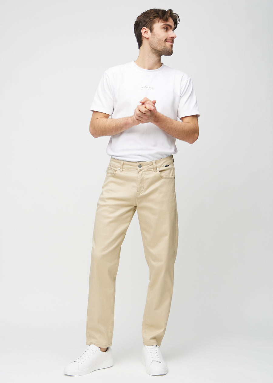 Fullt bilde av modell i beige regular jeans.