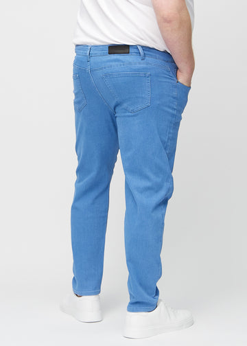 Blå regular jeans sett bakfra på en plus-size-modell, slik at man kan se hele produktet.