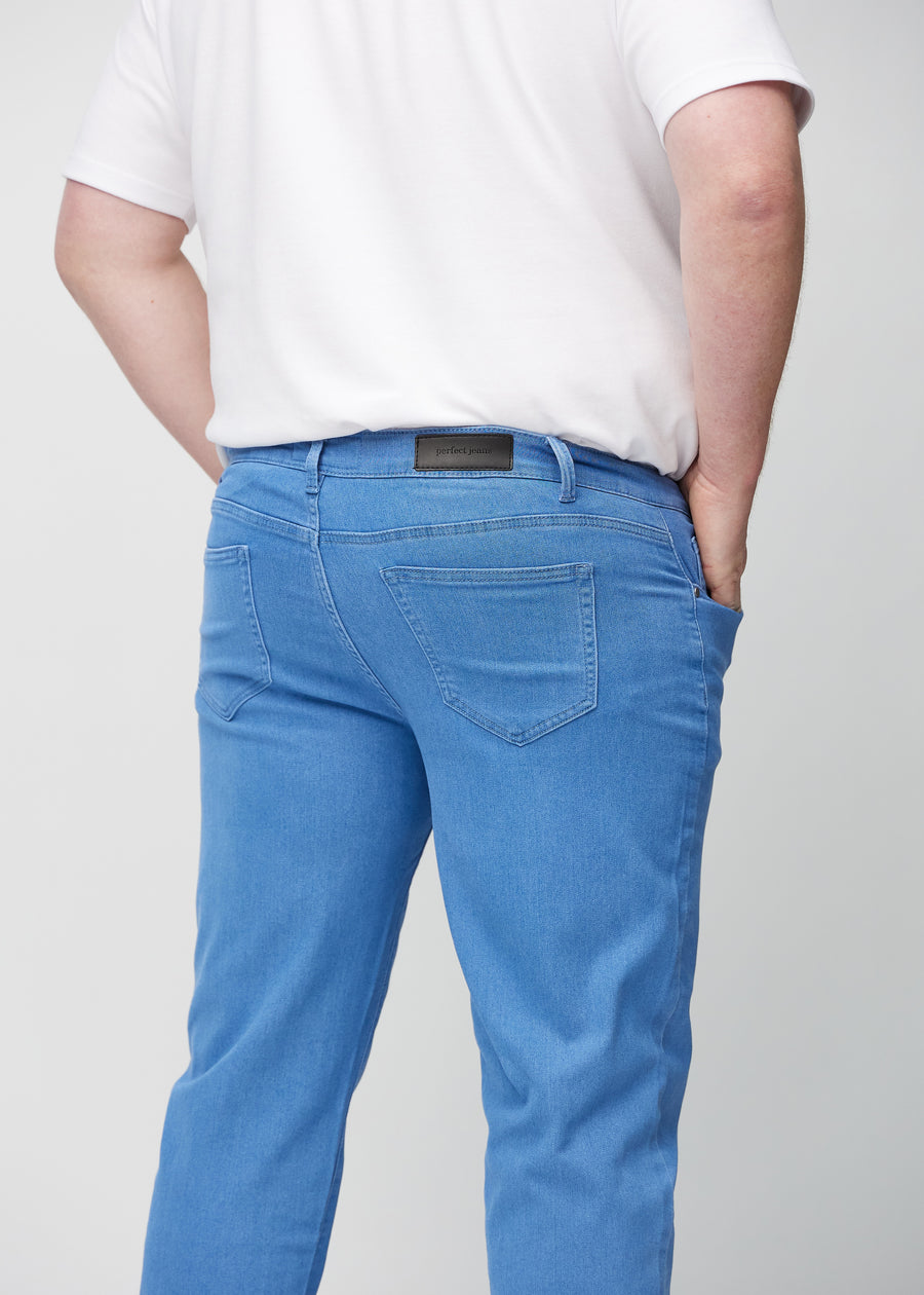 Blå regular jeans sett bakfra på nært hold på en plus-size-modell for å vise detaljer.