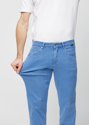 Modellen strekker jeansene ved låret for å vise stretch.