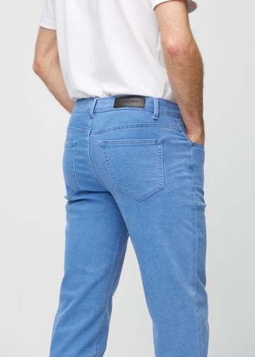 Blå regular jeans sett bakfra på nært hold for å vise detaljer.