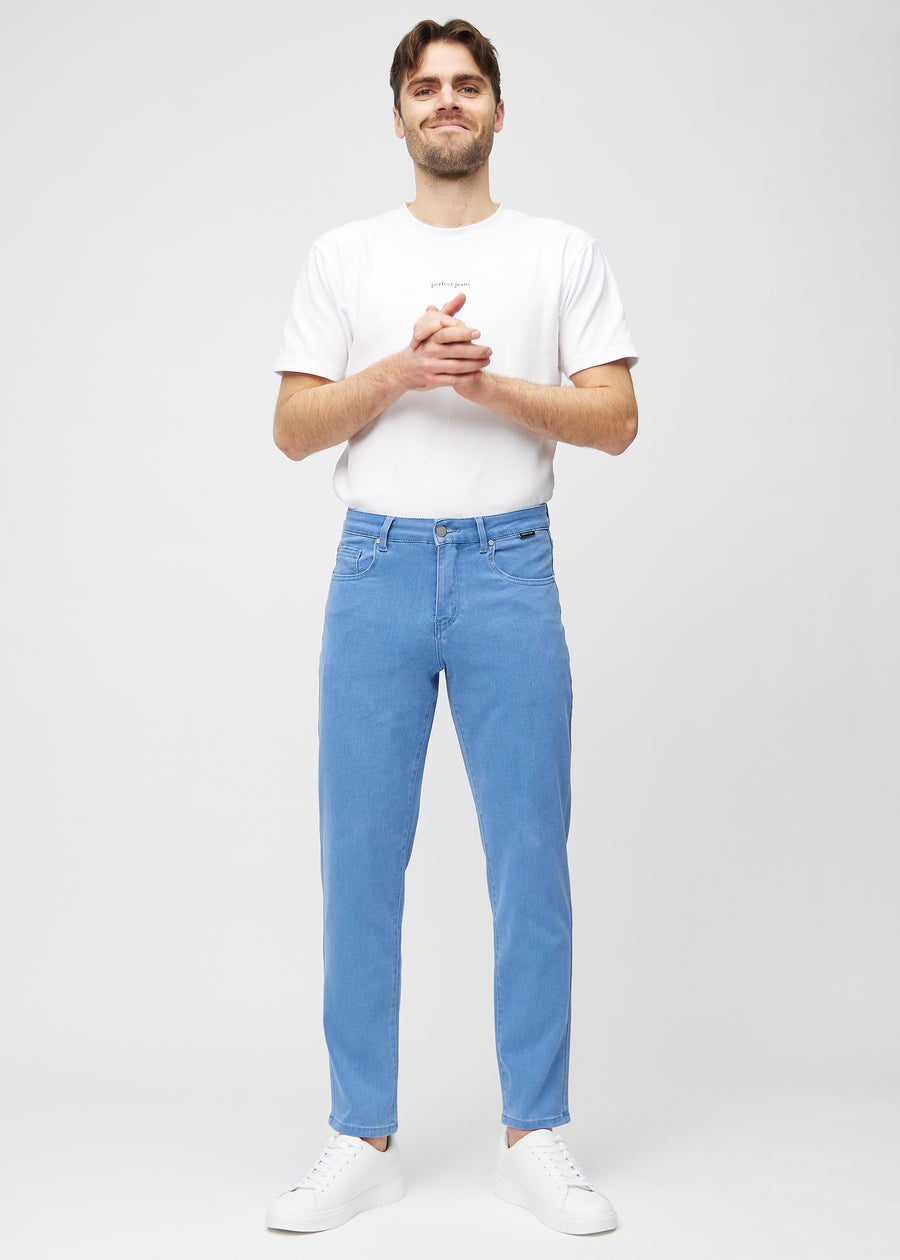 Fullt bilde av modell i blå regular jeans.