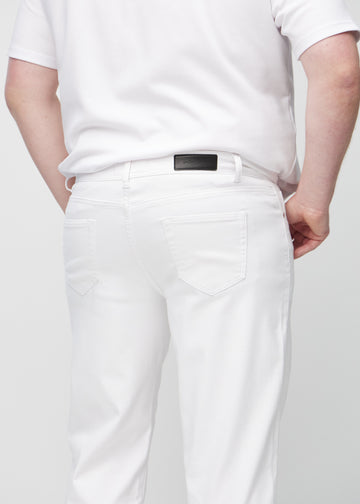 Hvite regular jeans sett bakfra på nært hold på en plus-size-modell for å vise detaljer.