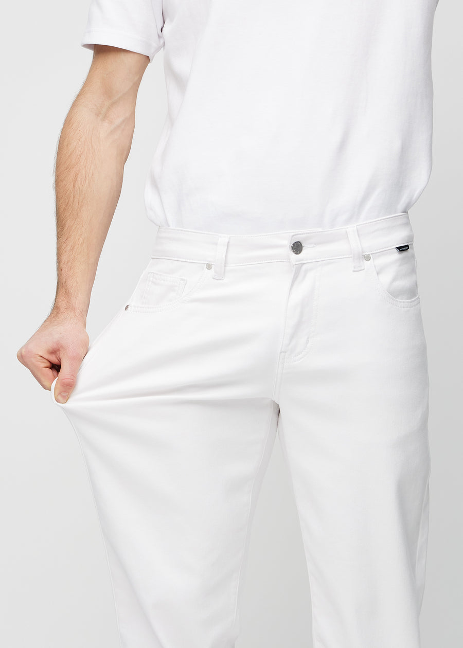 Modellen strekker jeansene ved låret for å vise stretch.