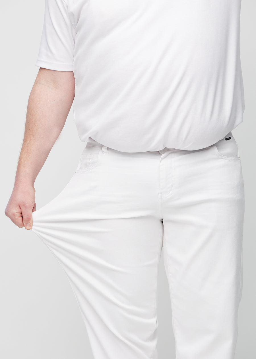Plus-size-modellen strekker jeansene ved låret for å vise stretch.