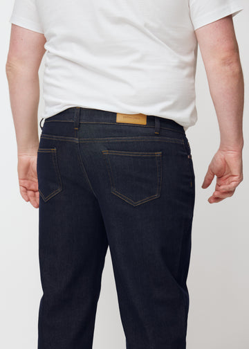 Dyp mørkeblå denim jeans til menn i fargen Midnights sett bakfra på nært hold på plus-size-modell.