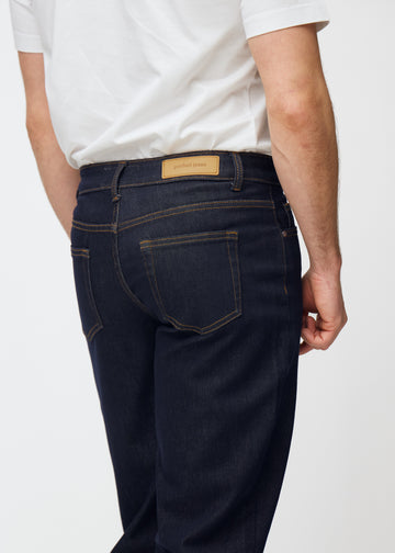 Dyp mørkeblå denim jeans til menn i fargen Midnights sett bakfra på nært hold for å vise passform og detaljer.
