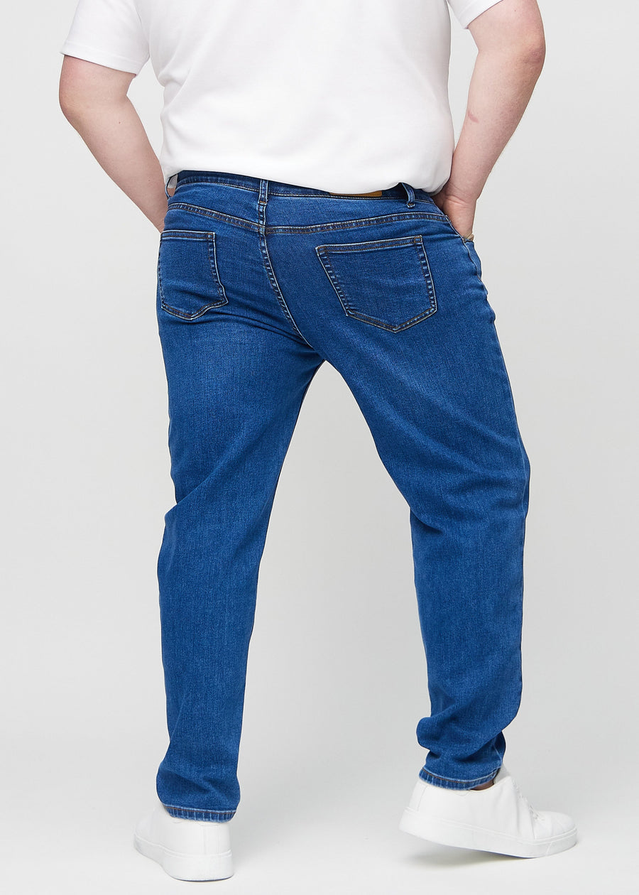 Mørkeblå denim regular jeans sett bakfra på en plus-size-modell, slik at man kan se hele produktet.