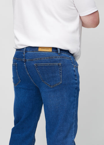 Mørkeblå denim regular jeans sett bakfra på nært hold på en plus-size-modell for å vise detaljer.