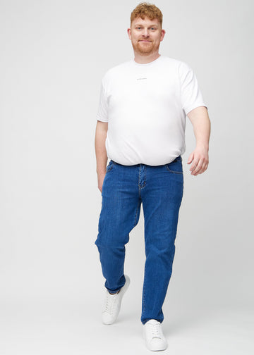 Fullt bilde av en plus-size-modell i mørkeblå denim regular jeans.