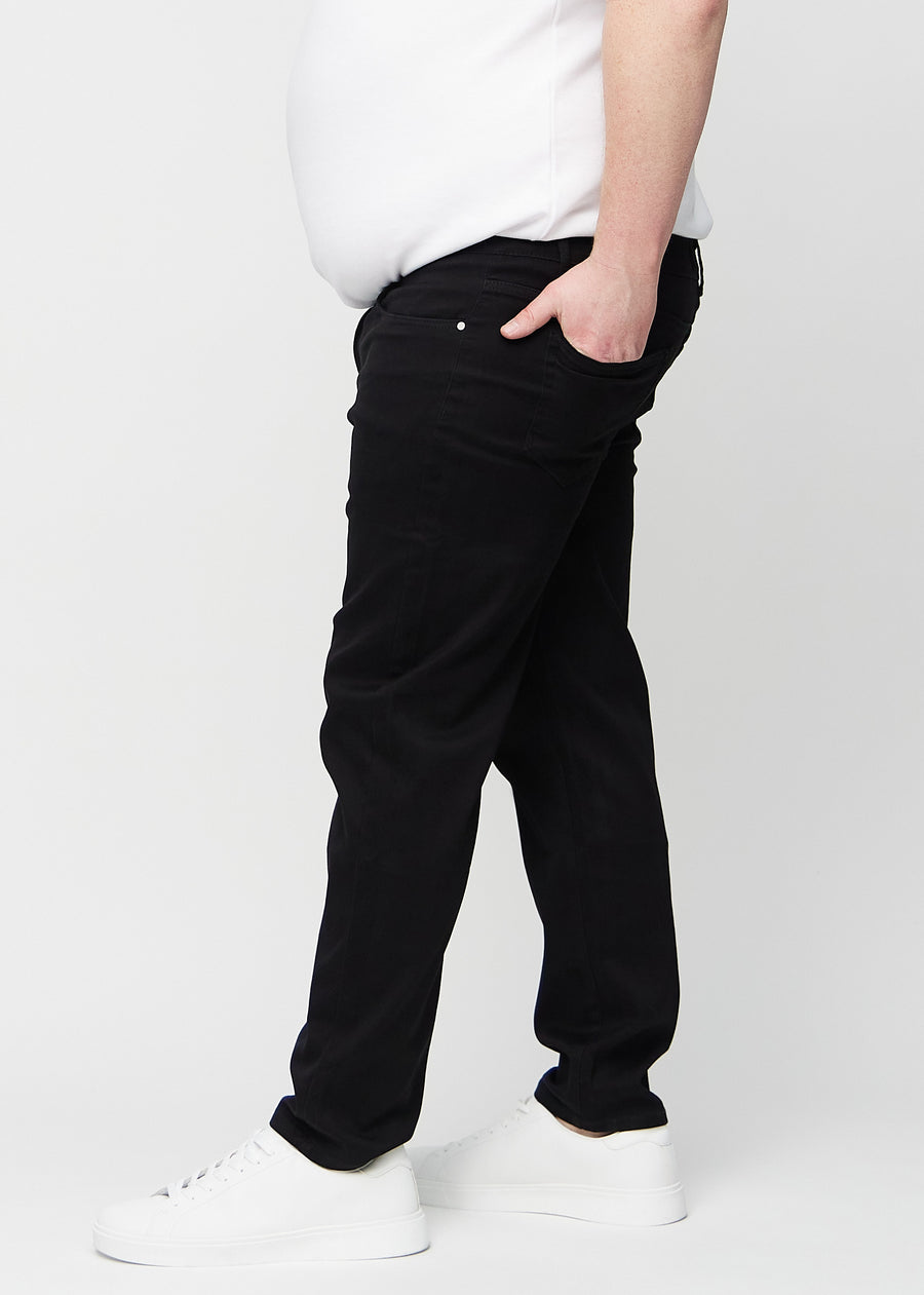 Svarte regular jeans sett fra siden på en plus-size-modell.