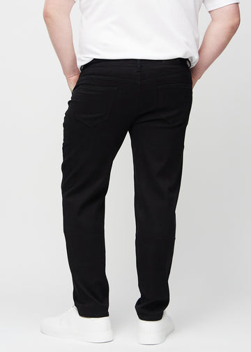 Svarte regular jeans sett bakfra på en plus-size-modell, så man kan se hele produktet.