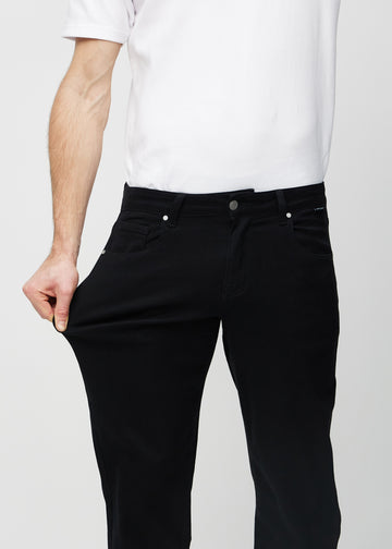 Modellen strekker jeansene ved låret for å vise stretch.
