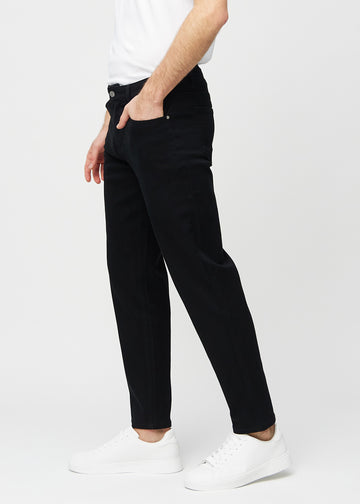 Svarte regular jeans sett fra siden på modell.