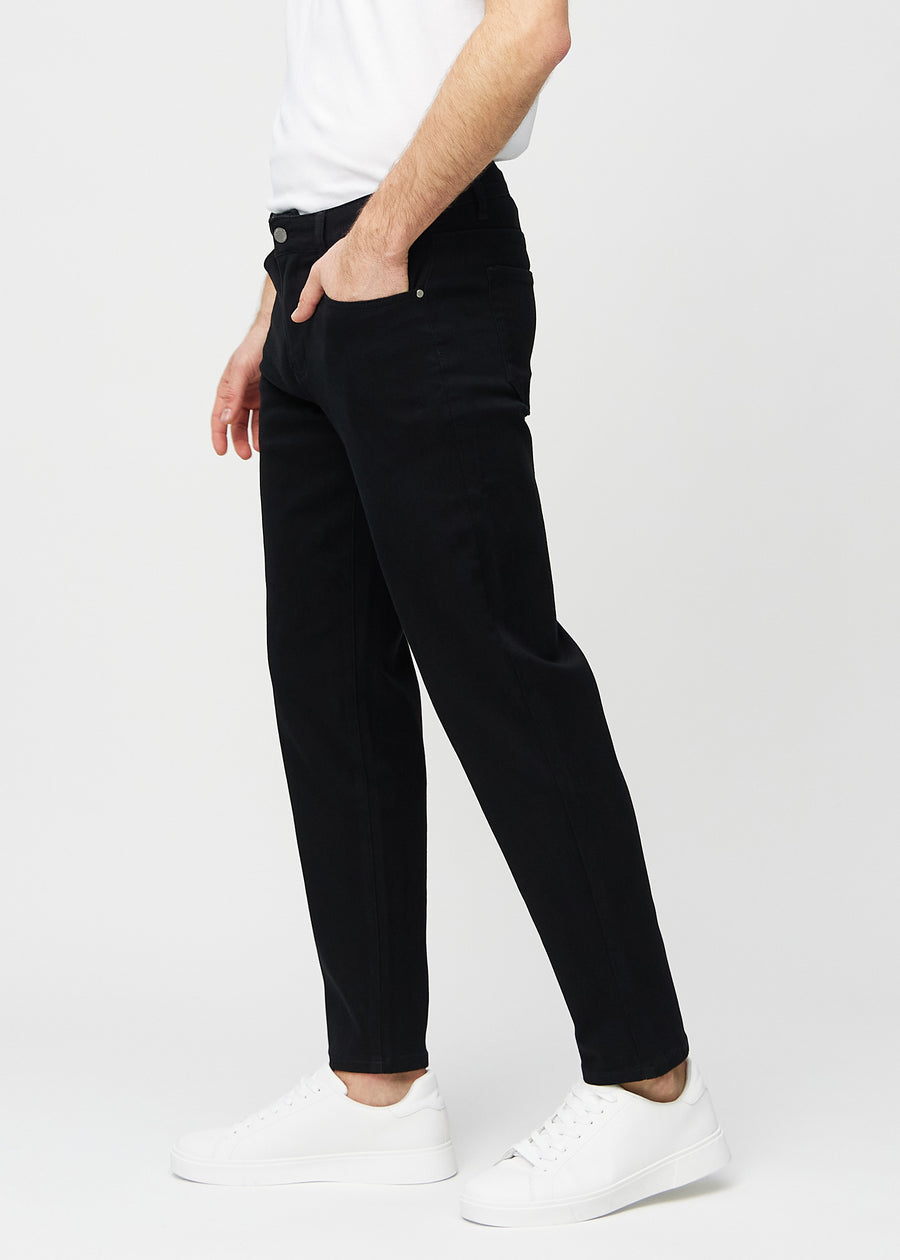 Svarte regular jeans sett fra siden på modell.