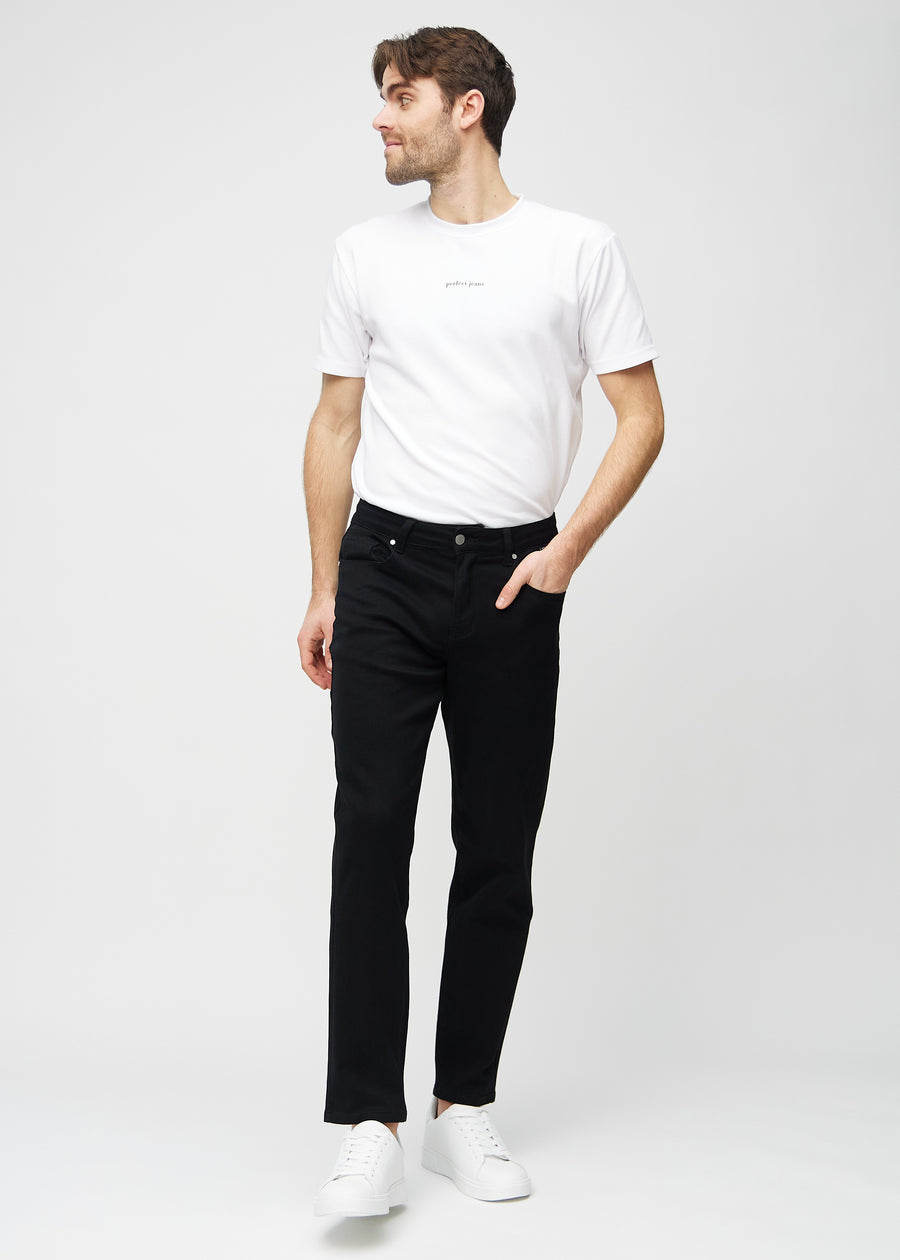 Fullt bilde av modell i svarte regular jeans.