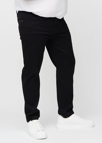 Svarte regular jeans, modellnavn Ravens, som går rett ned langs benet på en plus-size-modell, sett forfra.