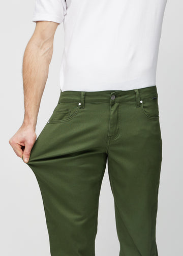 Modellen strekker jeansene ved låret for å vise stretch.