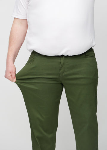 Plus-size-modellen strekker jeansene ved låret for å vise stretch.