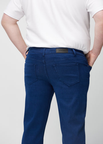 Mørkeblå regular jeans sett bakfra på nært hold på en plus-size-modell for å vise detaljer.