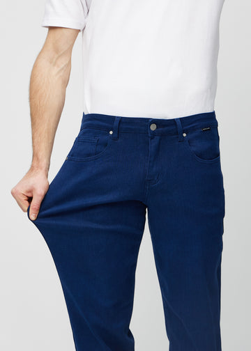Modellen strekker jeansene ved låret for å vise stretch.