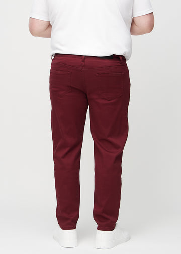 Mørkerøde regular jeans sett bakfra på en plus-size-modell, så man kan se hele produktet.
