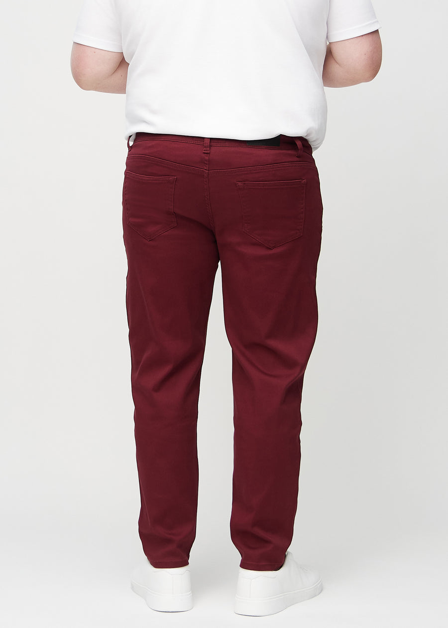 Mørkerøde regular jeans sett bakfra på en plus-size-modell, så man kan se hele produktet.
