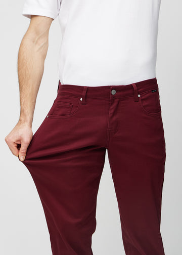 Modellen strekker jeansene ved låret for å vise stretch.
