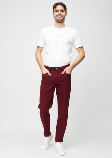 Fullt bilde av modell i mørkerøde regular jeans.