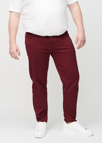 Mørkerøde regular jeans, modellnavn Santas, som går rett ned langs benet på en plus-size-modell, sett forfra.