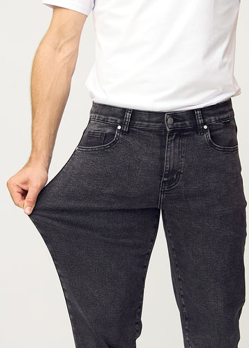 Modellen strekker jeansene ved låret for å vise stretch.