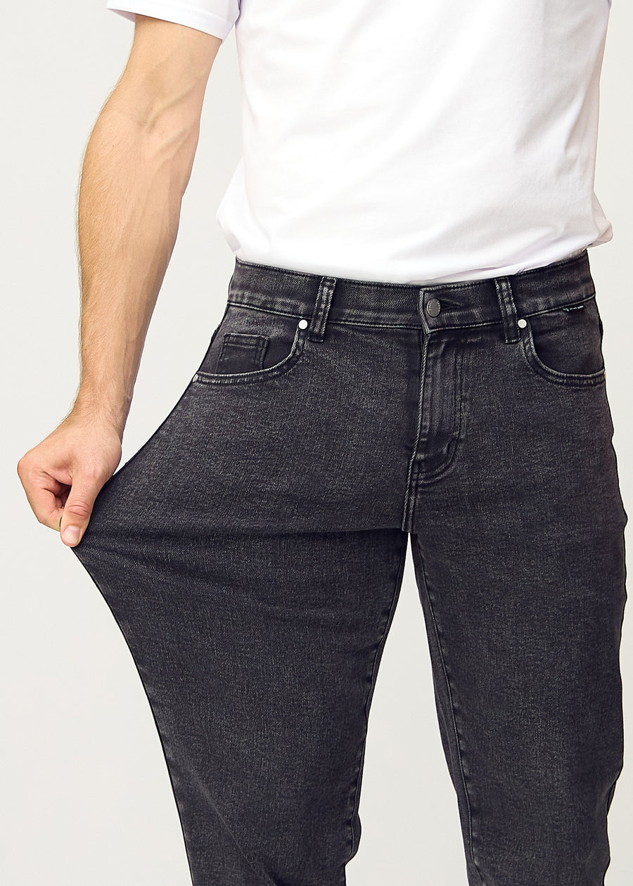 Modellen strekker jeansene ved låret for å vise stretch.