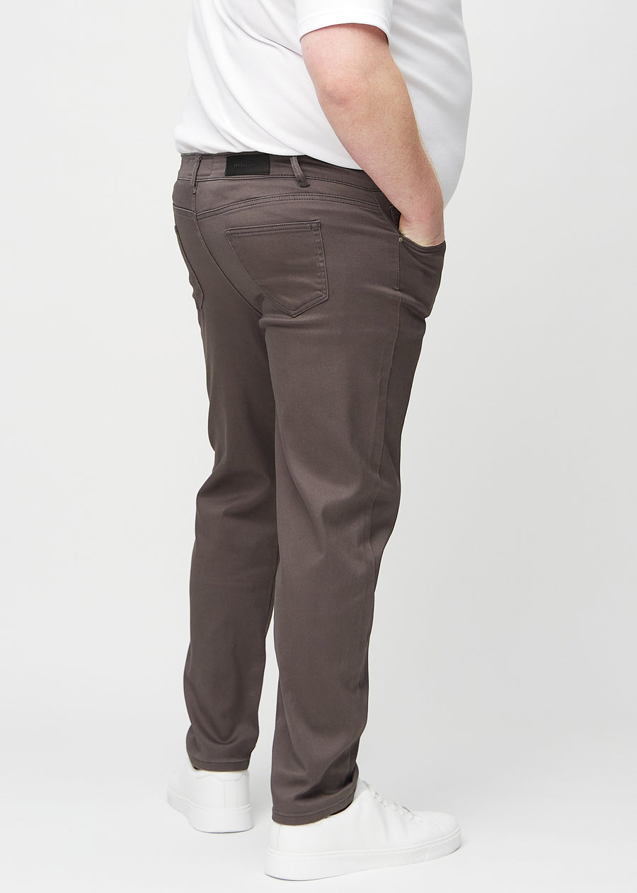 Gråbrune regular jeans sett bakfra på en plus-size-modell, så man kan se hele produktet.