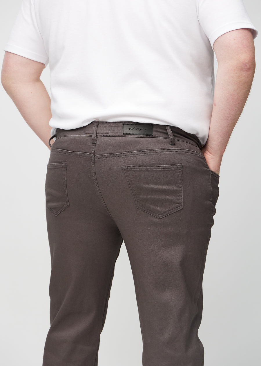Gråbrune regular jeans sett bakfra på nært hold på en plus-size-modell for å vise detaljer.