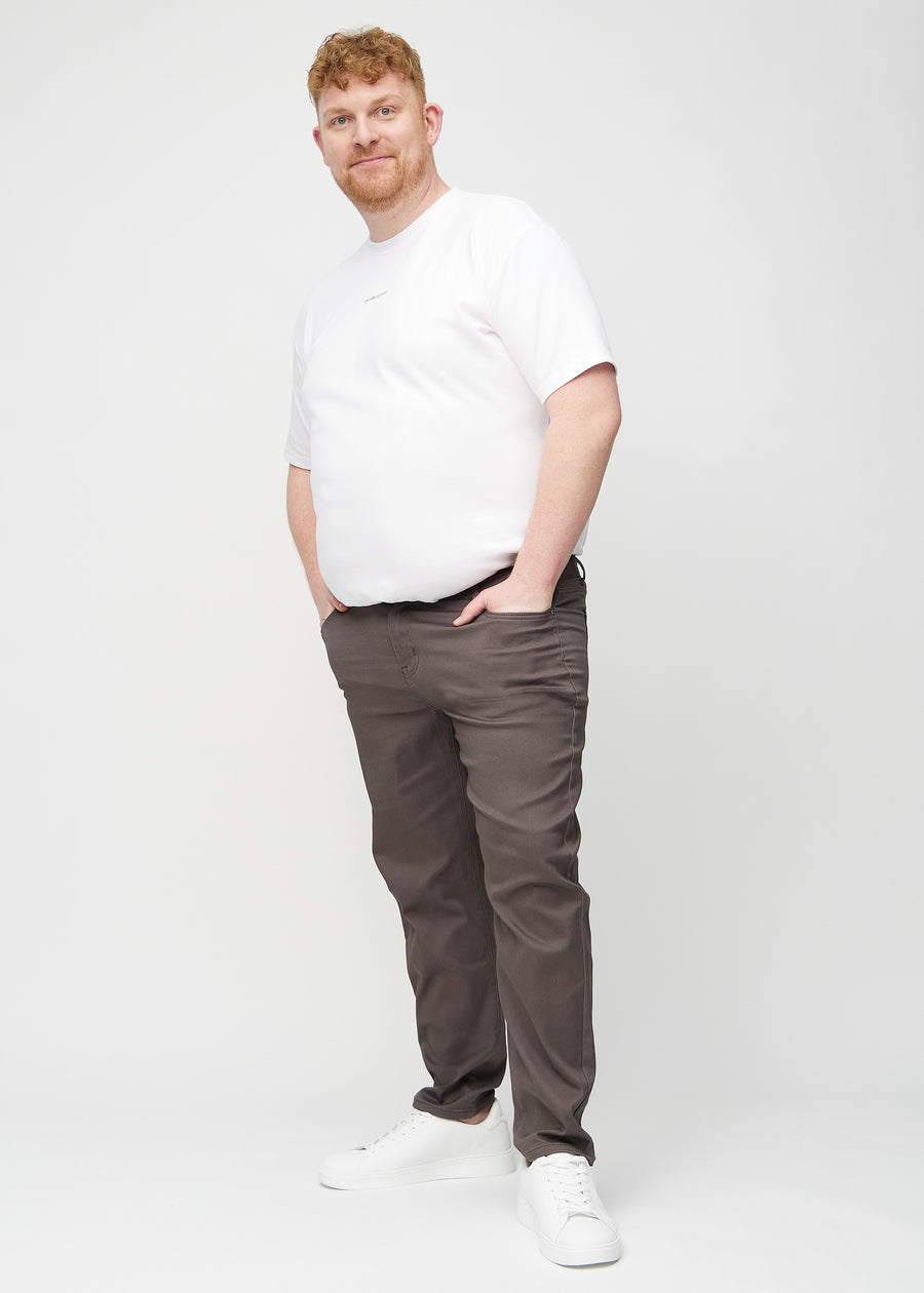 Fullt bilde av en plus-size-modell i gråbrune regular jeans.