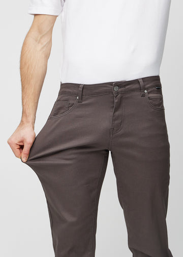 Modellen strekker jeansene ved låret for å vise stretch.