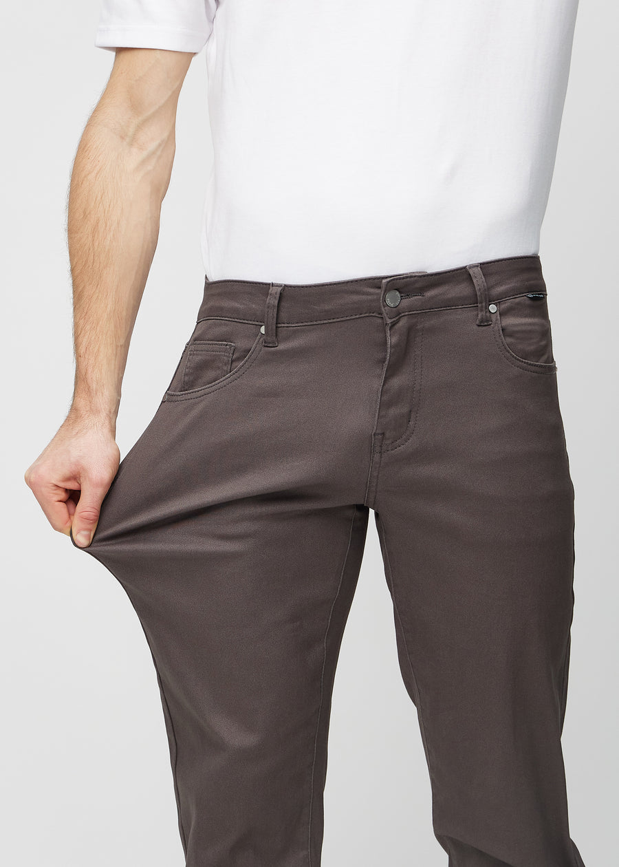 Modellen strekker jeansene ved låret for å vise stretch.