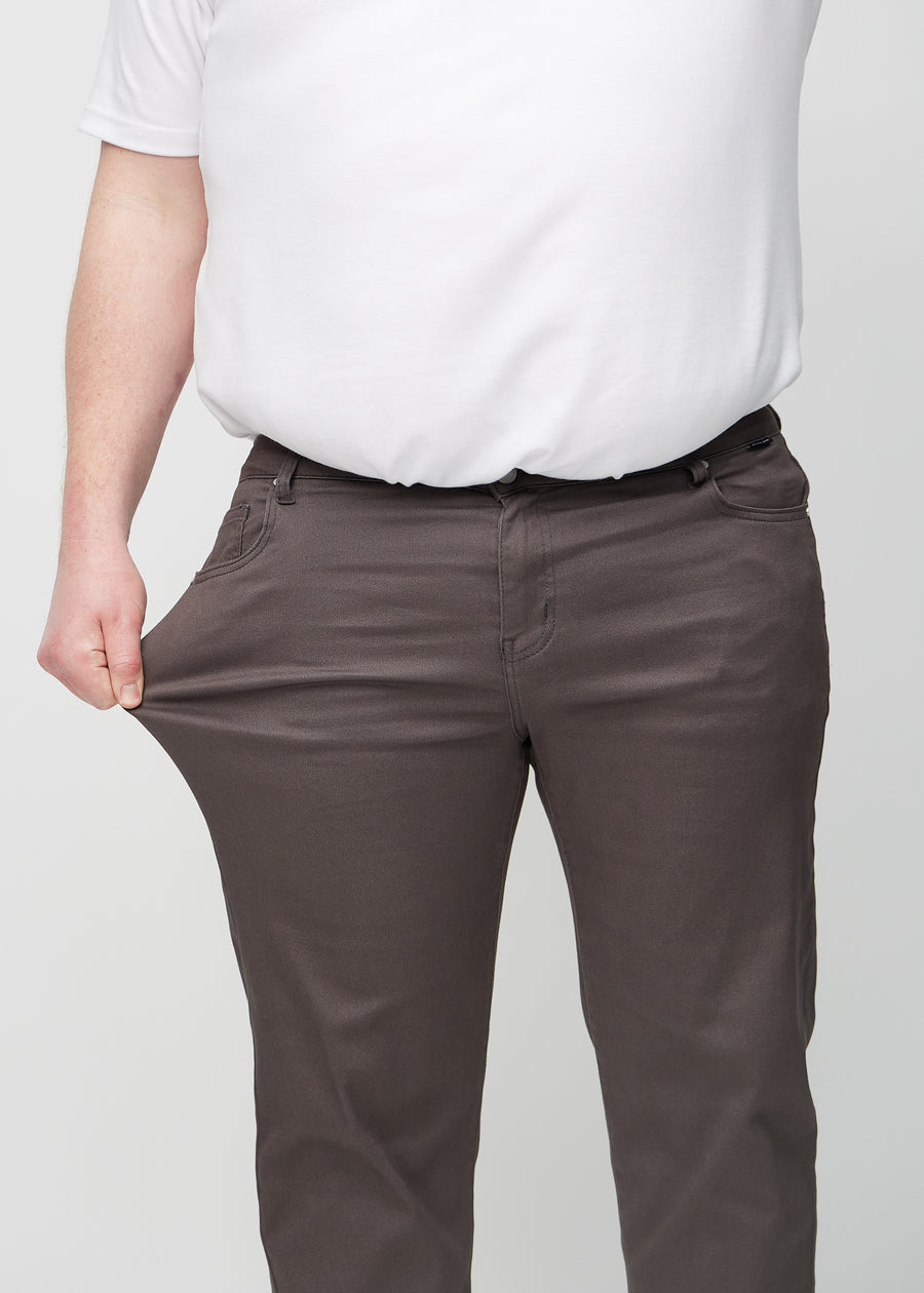 Plus-size-modellen strekker jeansene ved låret for å vise stretch.