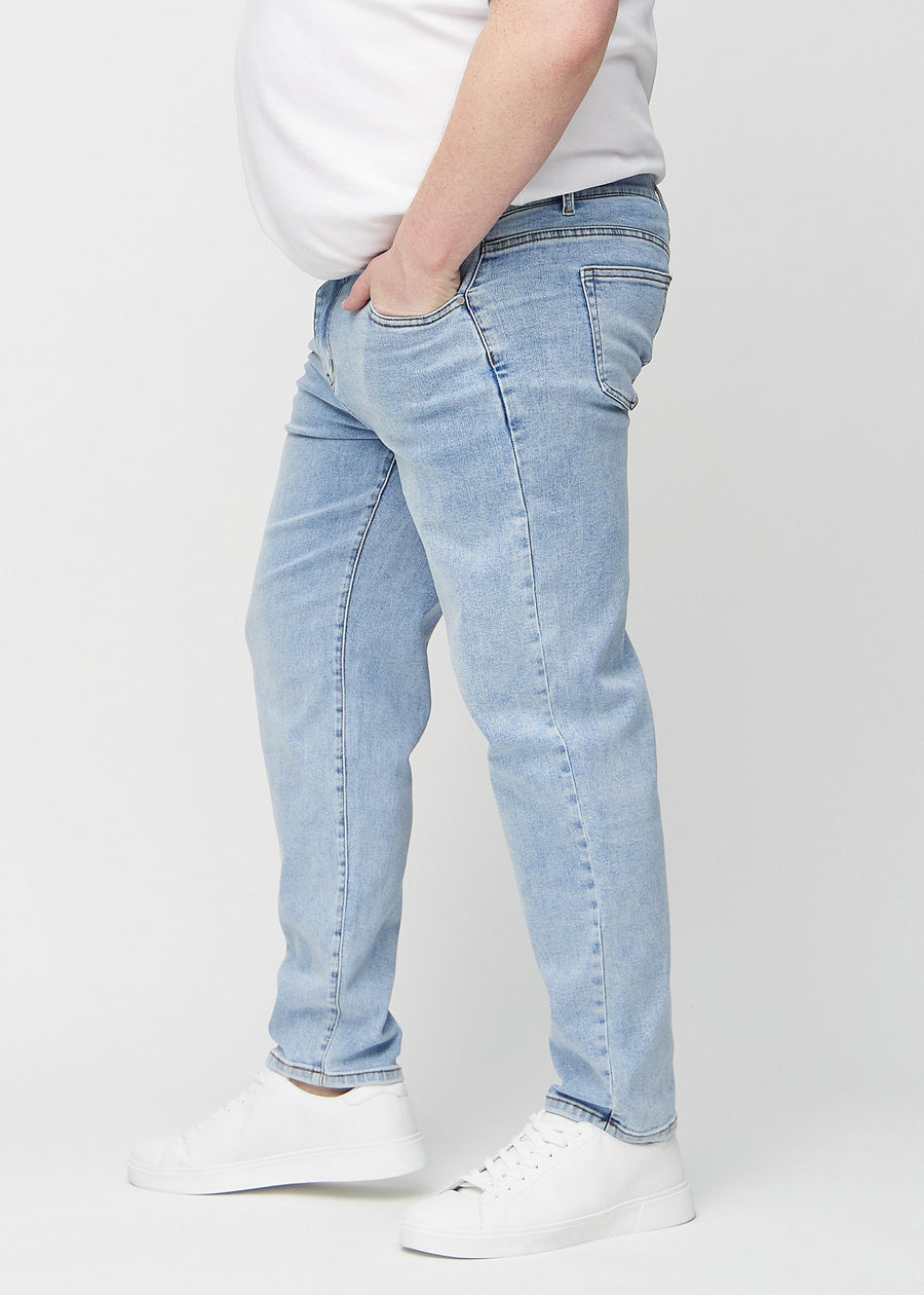 Lys denim regular jeans sett fra siden på en plus-size-modell.