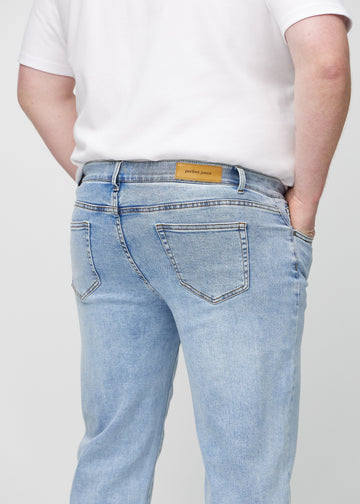 Lys denim regular jeans sett bakfra på nært hold på en plus-size-modell for å vise detaljer.