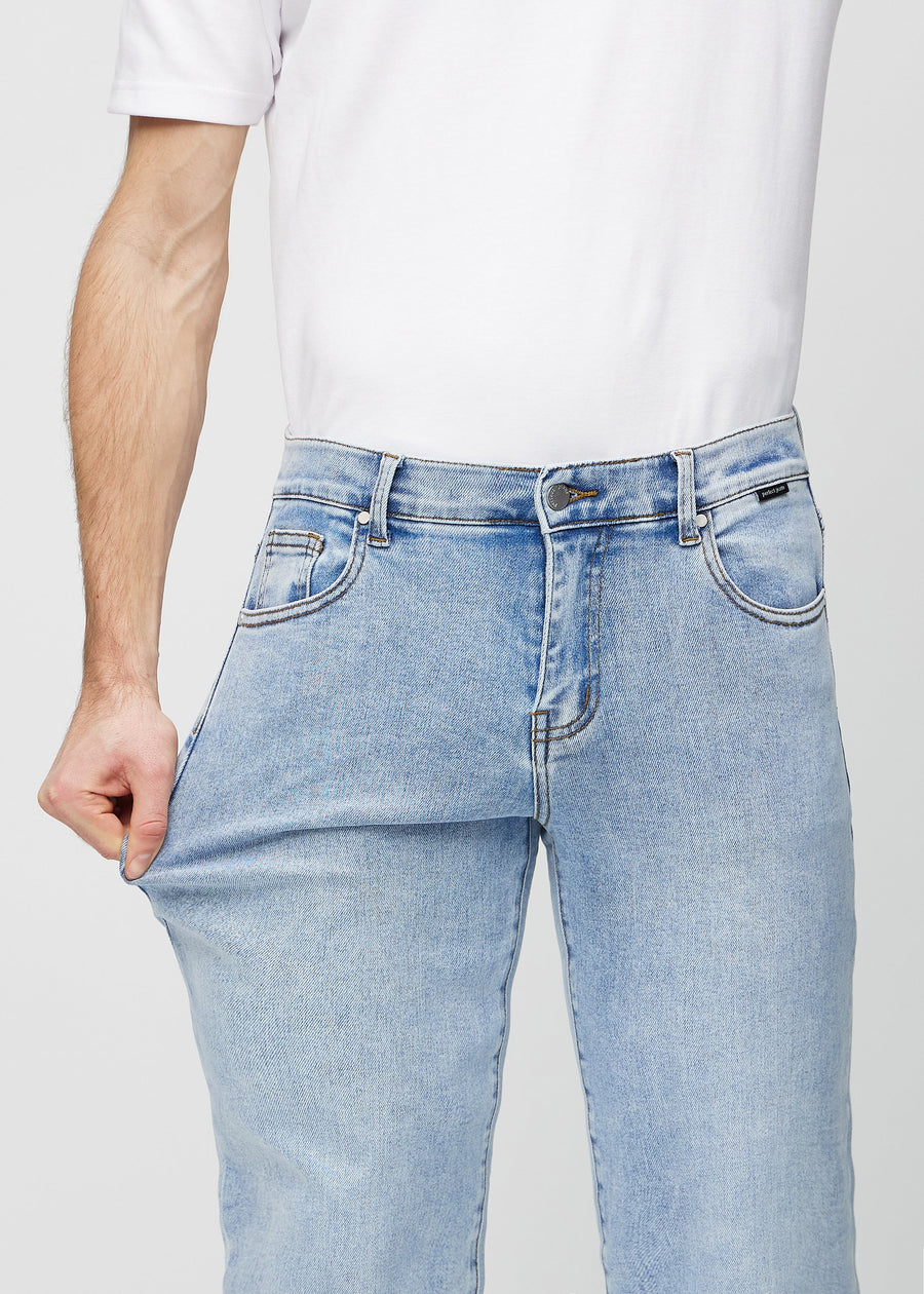 Modellen strekker jeansene ved låret for å vise stretch.
