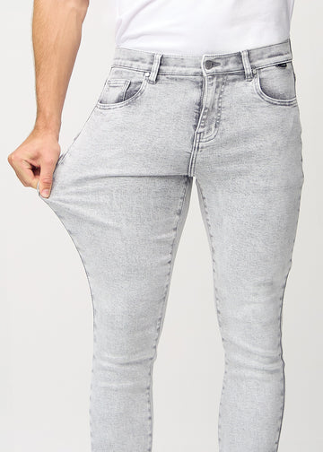 Modell strekker jeansene ved låret for å vise materialets stretch.