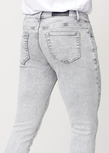 Nærbilde bakfra av lysegrå denimjeans i slim fit som viser detaljer.
