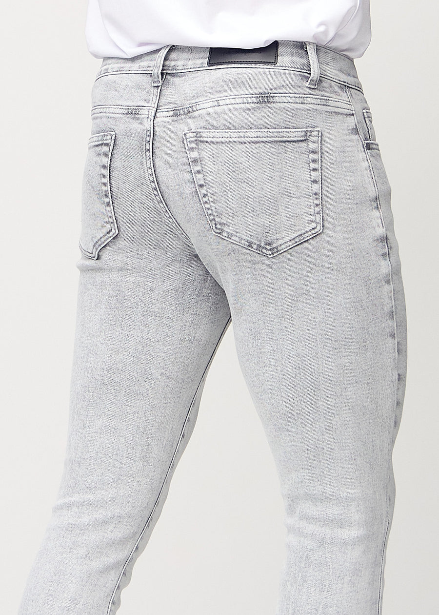 Nærbilde bakfra av lysegrå denimjeans i slim fit som viser detaljer.