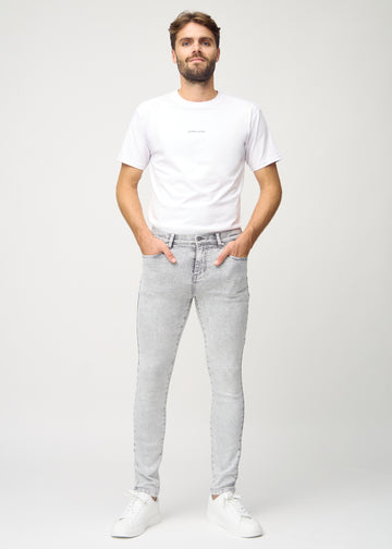Helbilde av en modell i lysegrå denimjeans i slim fit.