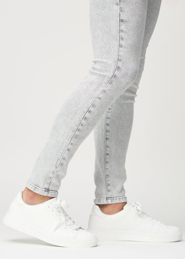 Anklene på en modell som viser hvor tett jeansene sitter.
