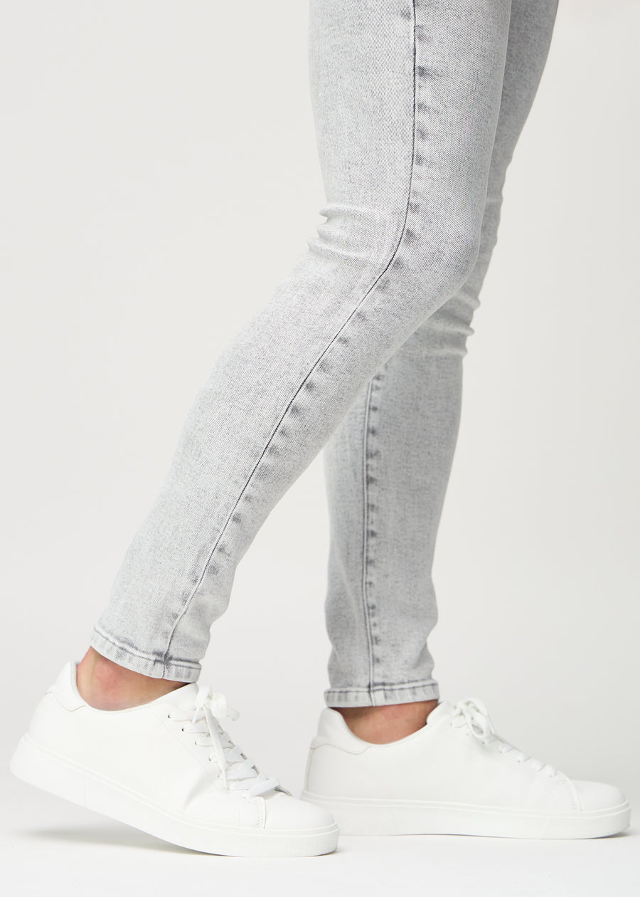 Anklene på en modell som viser hvor tett jeansene sitter.